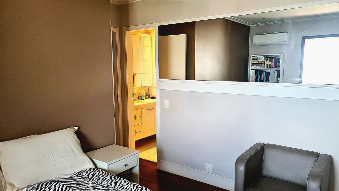 Suíte layout 2: Cama na frente do armário. Banheiro clean com movelaria em laca branca e armário superior com espelho 